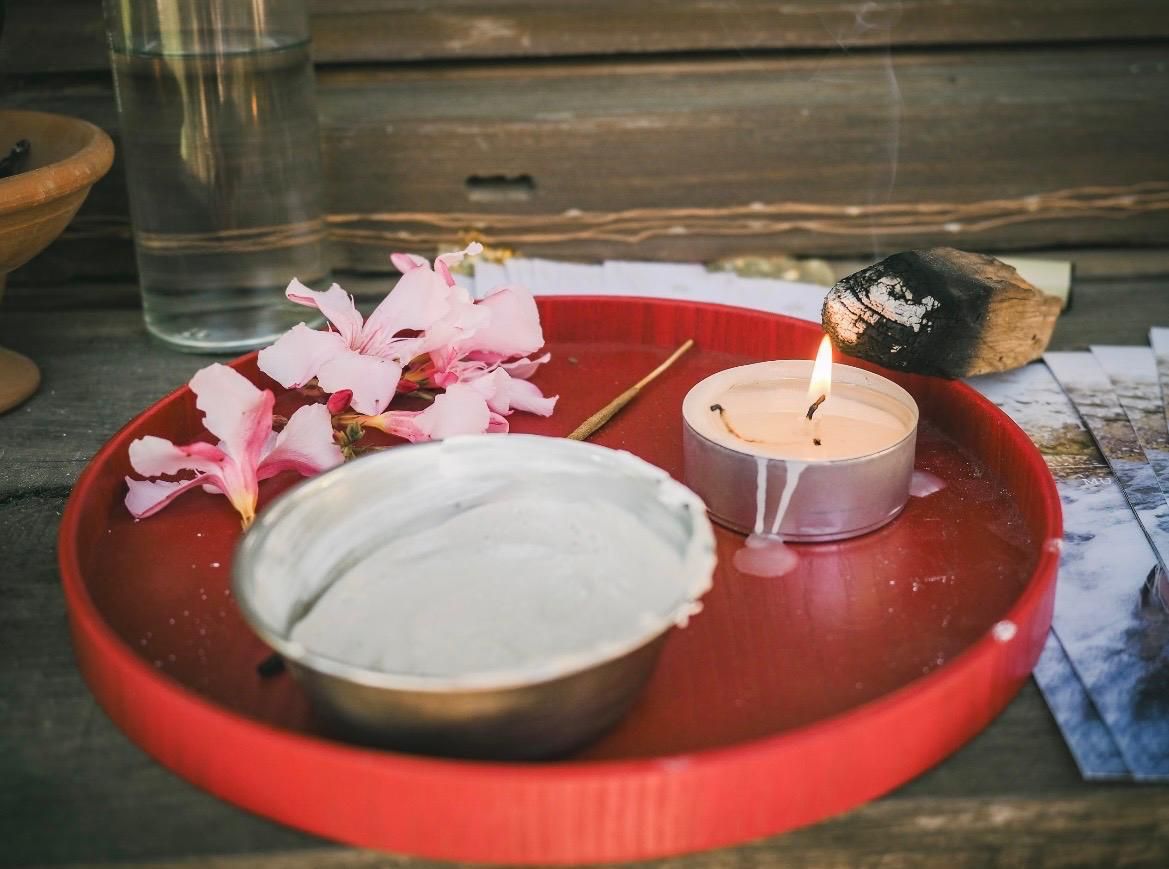Bandeja con vela, flores y palo santo preparada para un ritual en el retiro